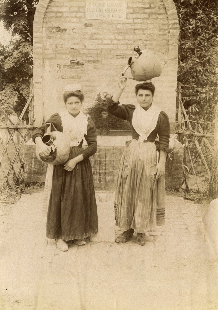 Dvě mladé ženy v tradičních oděvech a s terakotovými nádobami u studny, Marche, Itálie, asi 1910 od Italian Photographer