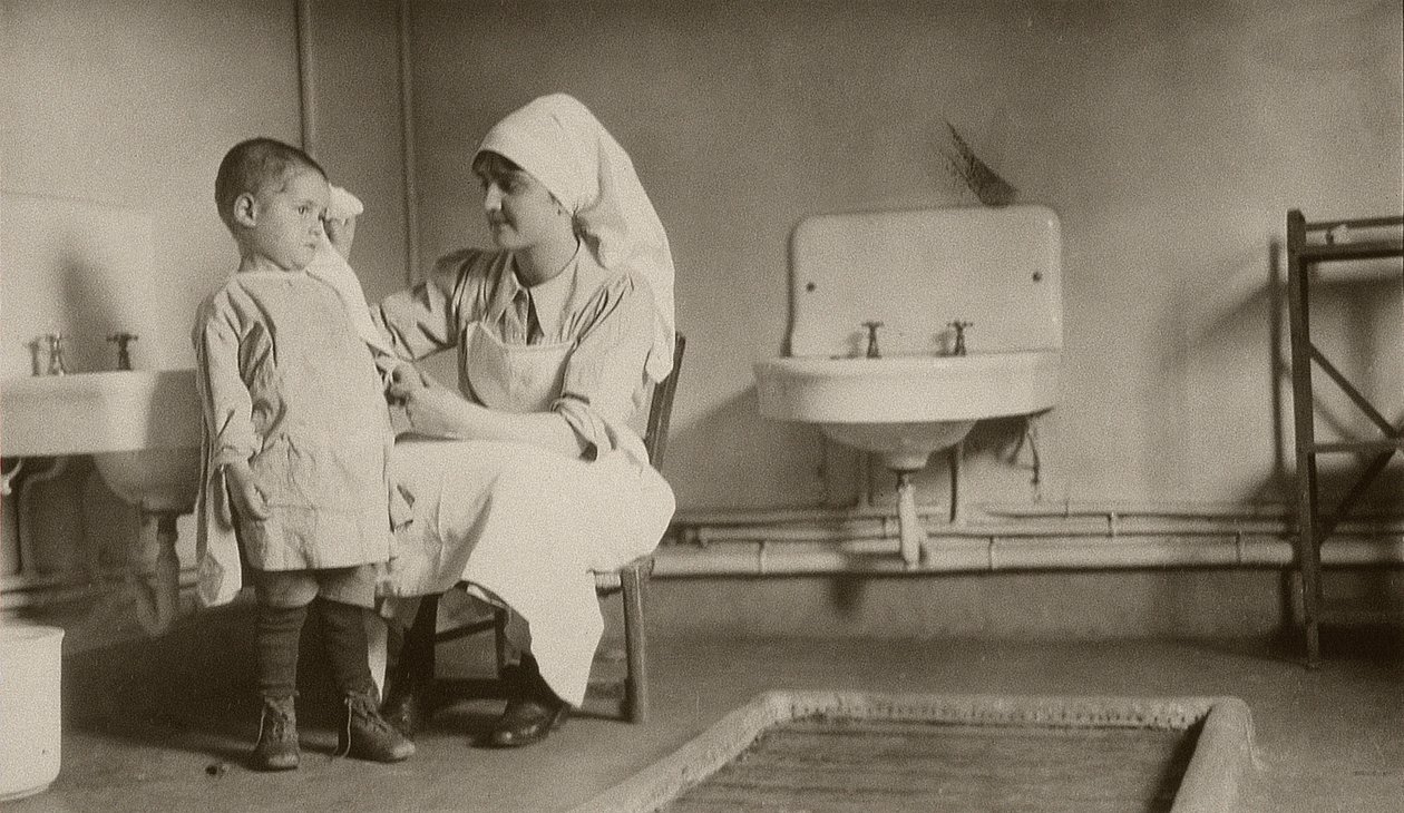 Zdravotní sestra pečující o nemocné dítě v koloniích Passay a Saint-Quentin pro uprchlíky a sirotky, 1919 od American Photographer