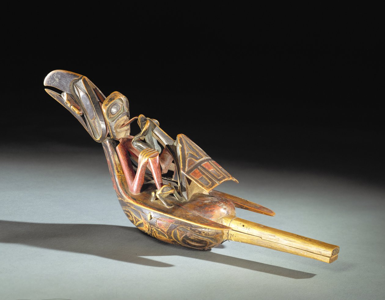 Tsimshian havraní chrastítko (dřevo, pigment, chrastítka, bavlněný provázek) od Canadian School