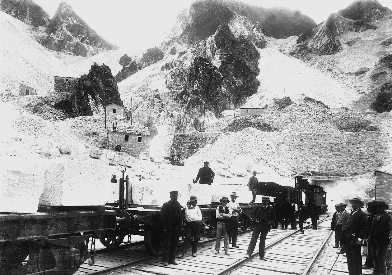 Bagry před železničním konvojem naloženým bloky mramoru v Ravaccione v Apuánských Alpách (černobílá fotografie) od A. Corsini
