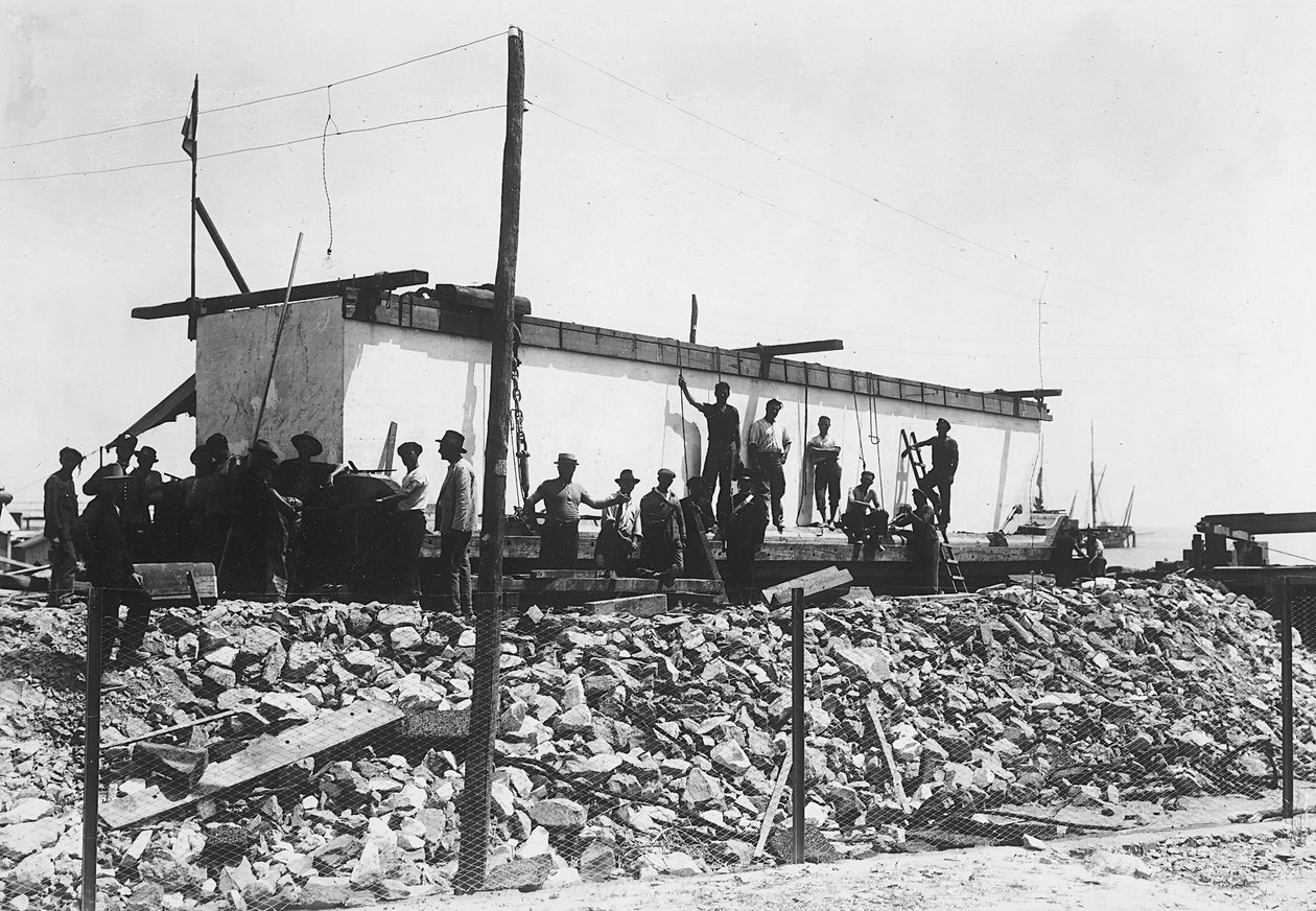 Několik mužů kolem obrovského bloku mramoru již bylo odříznuto, právě přepraveno do údolí z lomů v Apuánských Alpách (černobílá fotografie) od A. Corsini