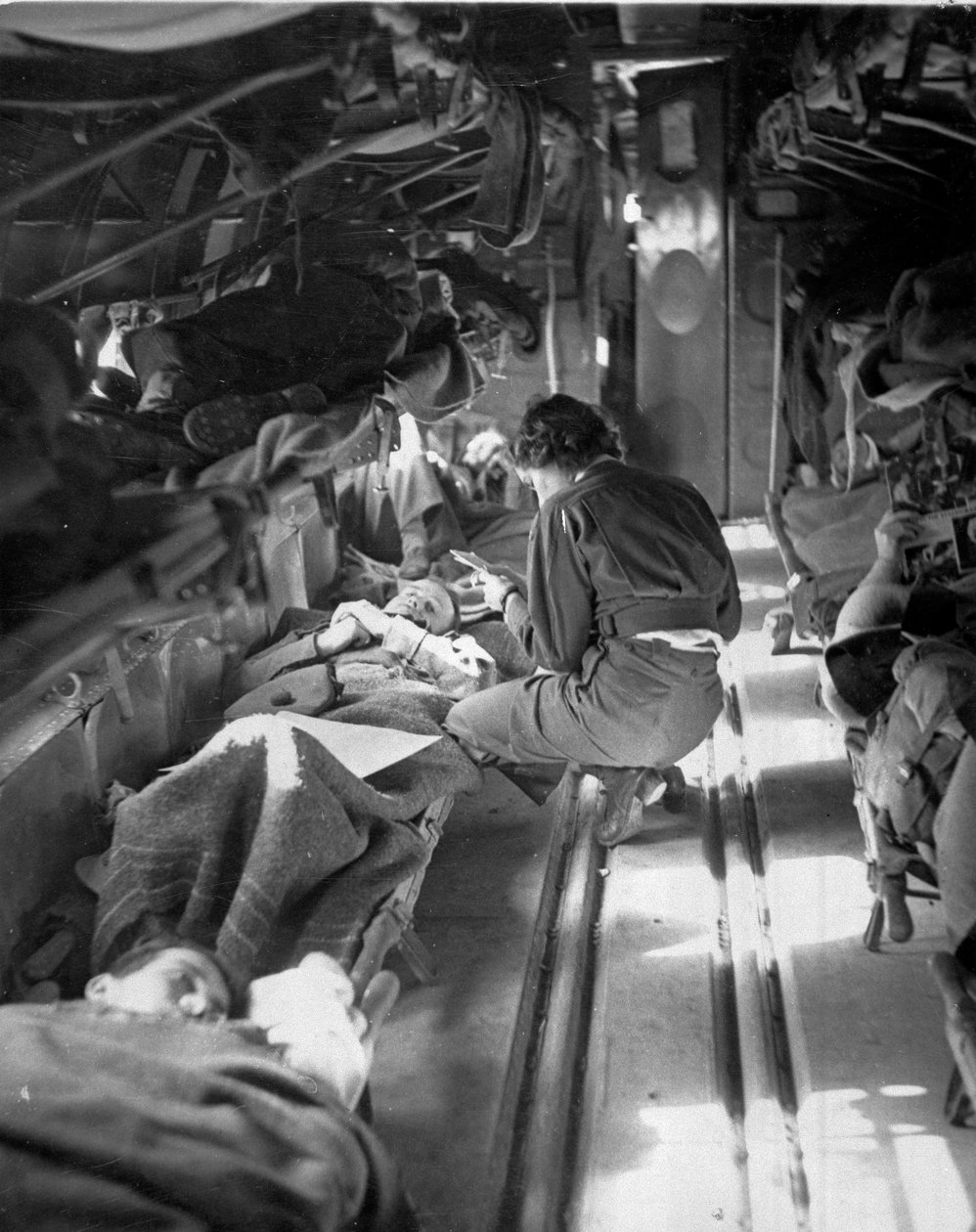 Slečna Mary Smithová z Jižní Karolíny ošetřující pacienty během letu do severní Afriky, cca 1943-1945, ze sbírky 650 fotografií sestavené Commando Association od American Photographer