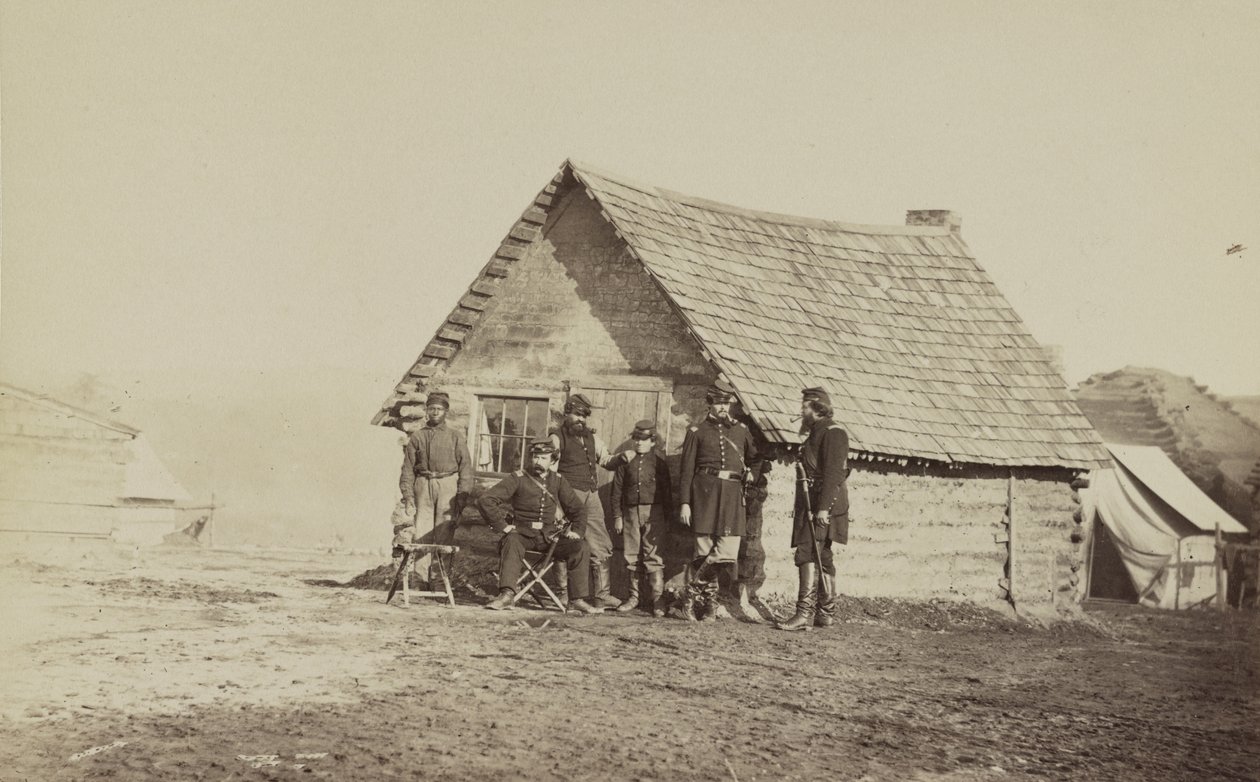 Skupina vojáků a dva mladí muži, jeden Afroameričan, stojí před srubem, 1861-65 od American Photographer