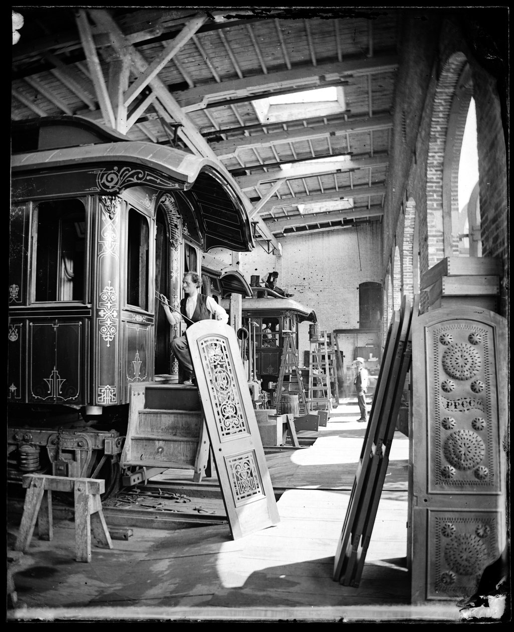 Vnitřní pohled na muže pracující v lakovně v Pullman Palace Cars Factory, pravděpodobně v Detroitu, Michigan od American Photographer