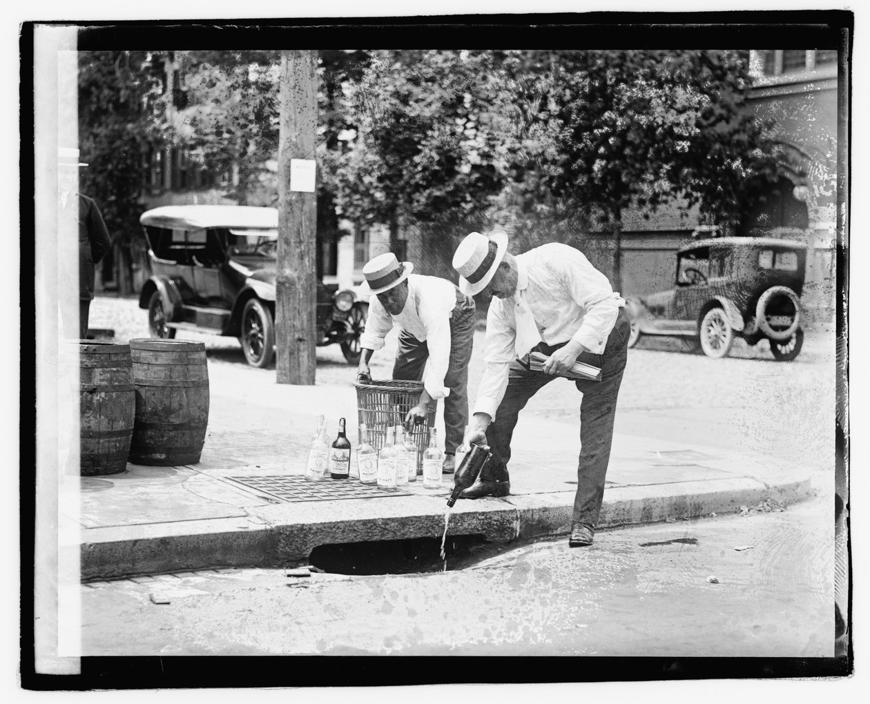 Dva muži nalévali kořalku do stoky, 8. července 1921 (černobílé foto) od American Photographer