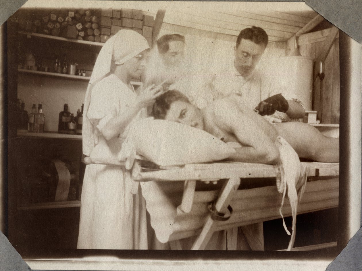 První světová válka 1914-1918: lékaři a zdravotní sestra ošetřovali zranění vojáka v šatně, tábor Couville v Lamanšském průlivu, Dolní Normandie (Dolní Normandie), Francie. Anonymní fotografie červenec 1917. Soukromá sbírka, Stella. od Anonymous Anonymous
