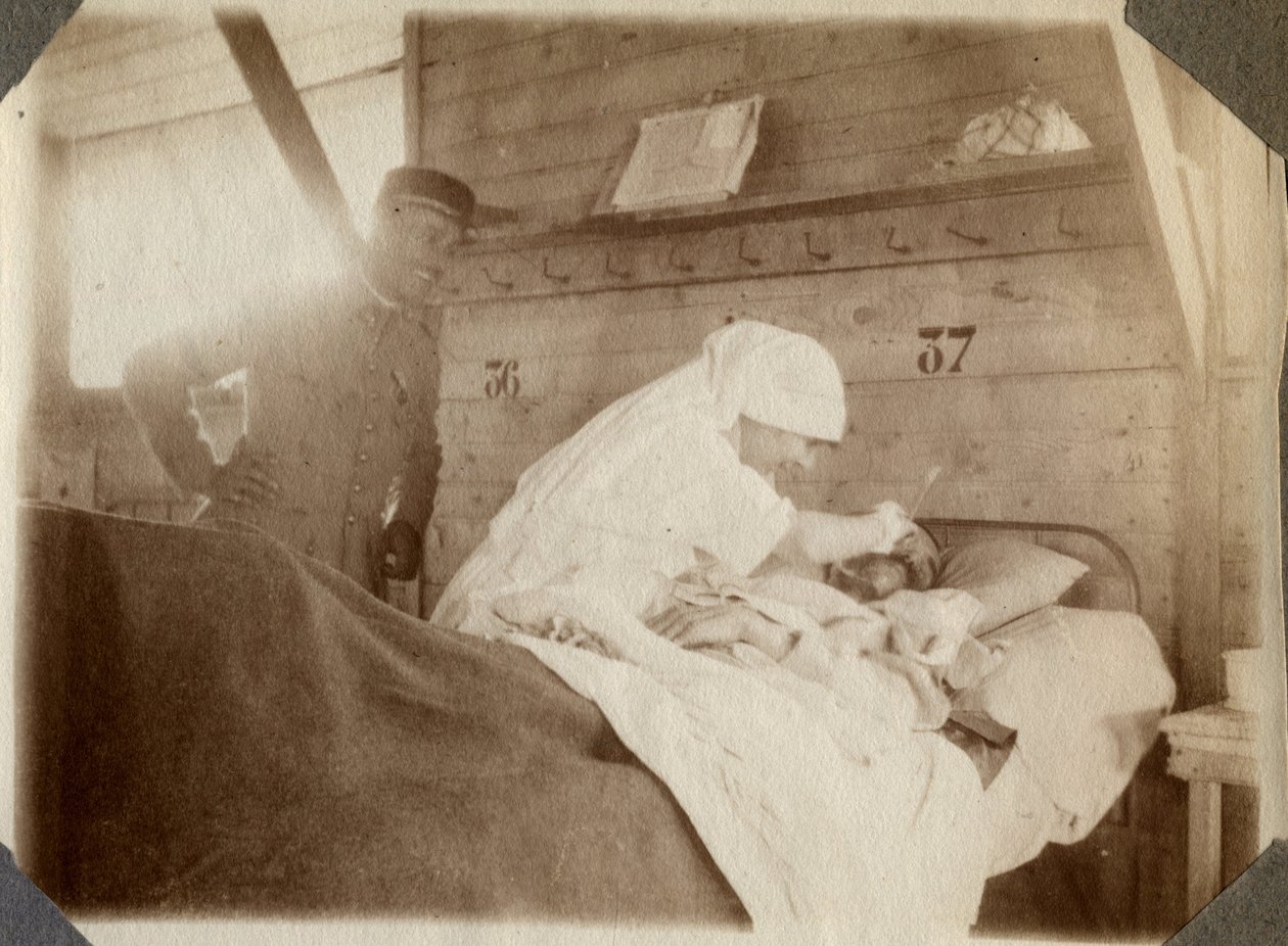 První světová válka 1914-1918: zdravotní sestra v blůze holí vojáka (francouzská válečná zranění leží v posteli), v Couville, Manche, Dolní Normandie (Dolní Normandie), Francie. Anonymní fotografie červenec 1917. Soukromá sbírka, Stella. od Anonymous Anonymous