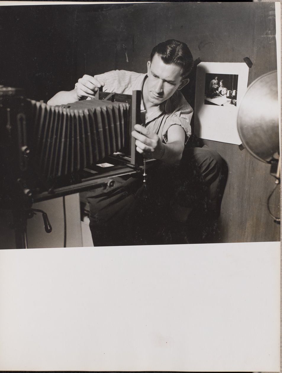 [Muž nastavuje skládací měch na velkoformátovém fotoaparátu] od Arnold Eagle