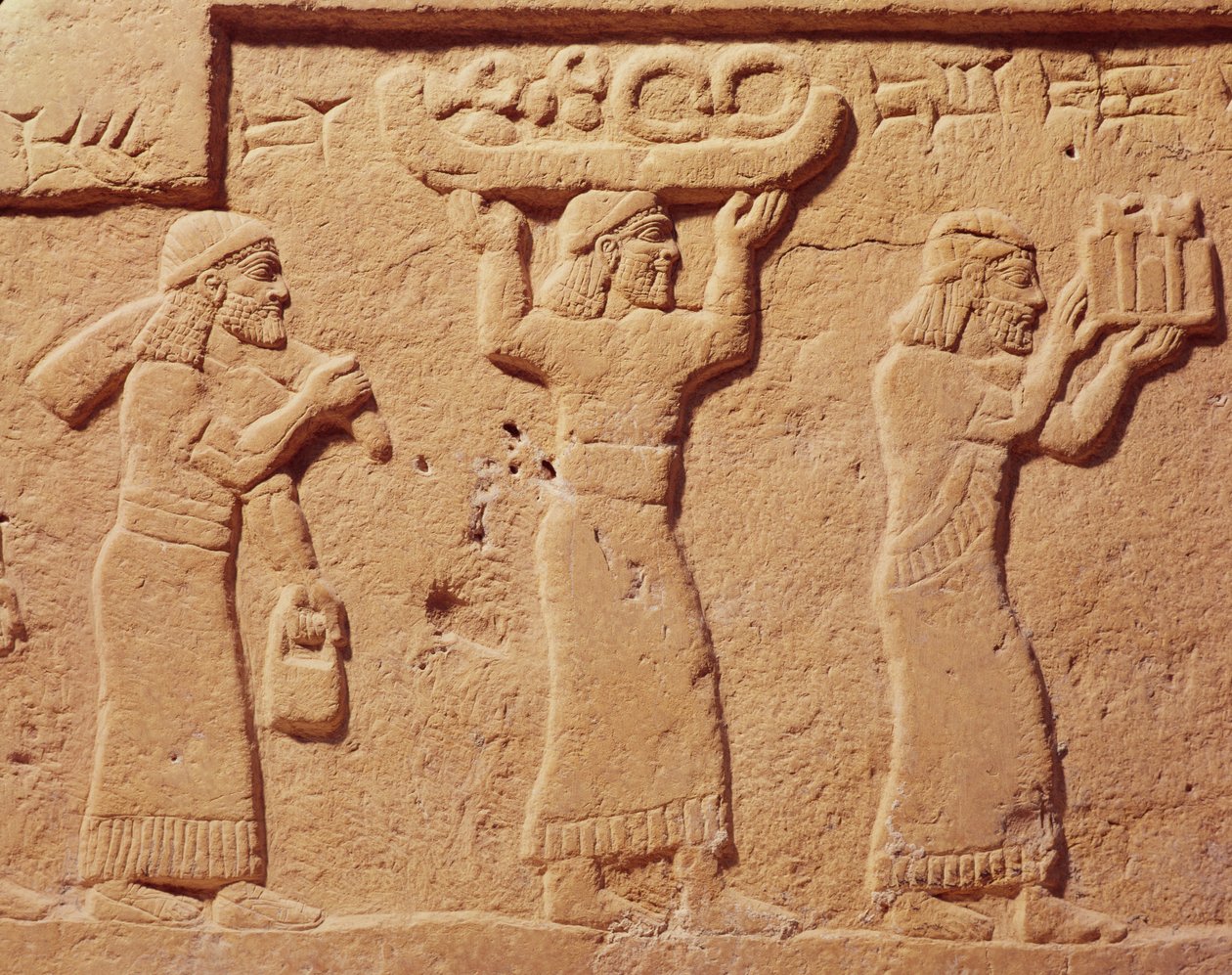 Reliéf zobrazující nosiče naložené dárky od Assyrian
