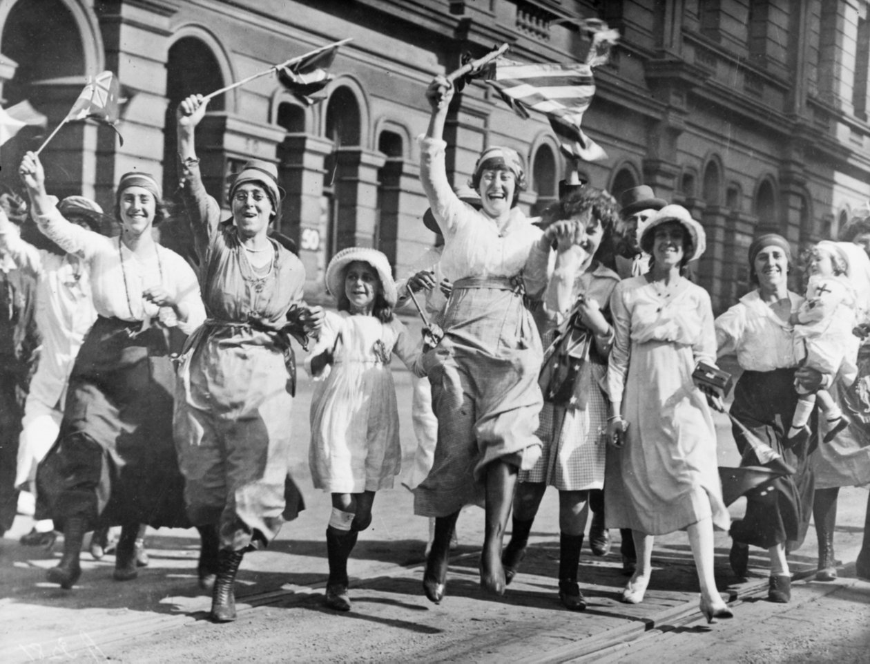Skupina žen a dětí se radující na ulici v Sydney při podpisu příměří, 11. listopadu 1918 od Australian Photographer
