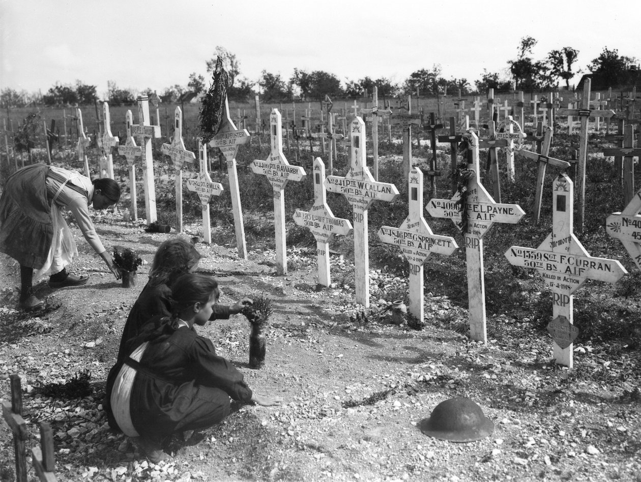 Francouzské děti pečující o hroby na hřbitově v Adelaide Australanů zabitých v bitvě na západní frontě, Villers-Bretonneux, Francie 26. srpna 1919 od Australian Photographer