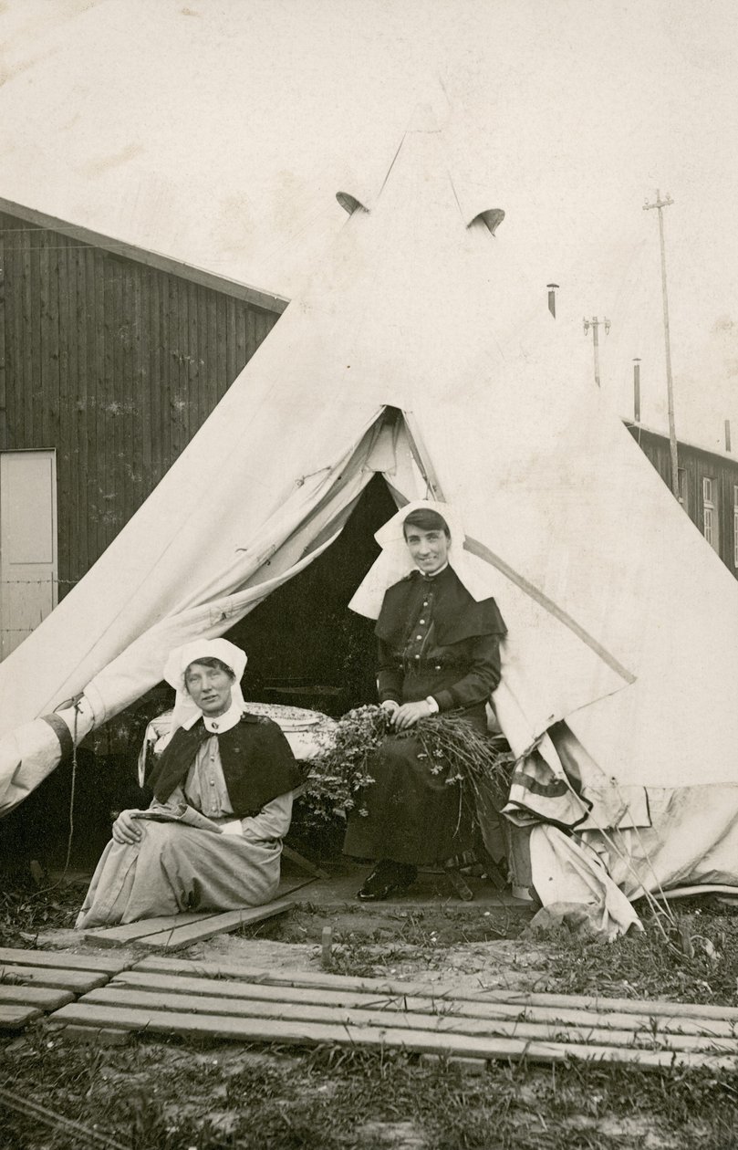 Sestra Eleanor Wibmer Jeffries a sestra Nellie Constance Morrice (vpravo) před svým stanem v australské všeobecné nemocnici č. 3 s květinami natrhanými z břehu řeky Somme, c. června 1917 (černobílá fotografie od Australian Photographer