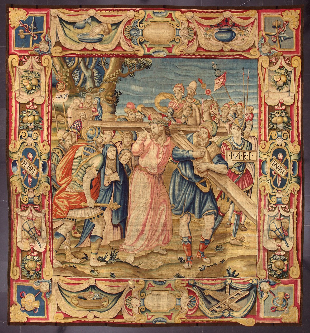 Kristus a Šimon z Kyrény (Kyréňan). (Páté zastavení křížové cesty (nesení kříže). Na části kříže je nápis I.N.R.I. (INRI). Tapiserie vyrobená v bruselských manufakturách. 16. století Ženeva, Musei di Strada Nuova. od Belgian School
