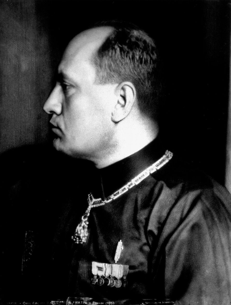 Polodélka z profilu Benita Mussoliniho v černé košili a vojenském vyznamenání (černobílá fotografie) od Brogi Brogi