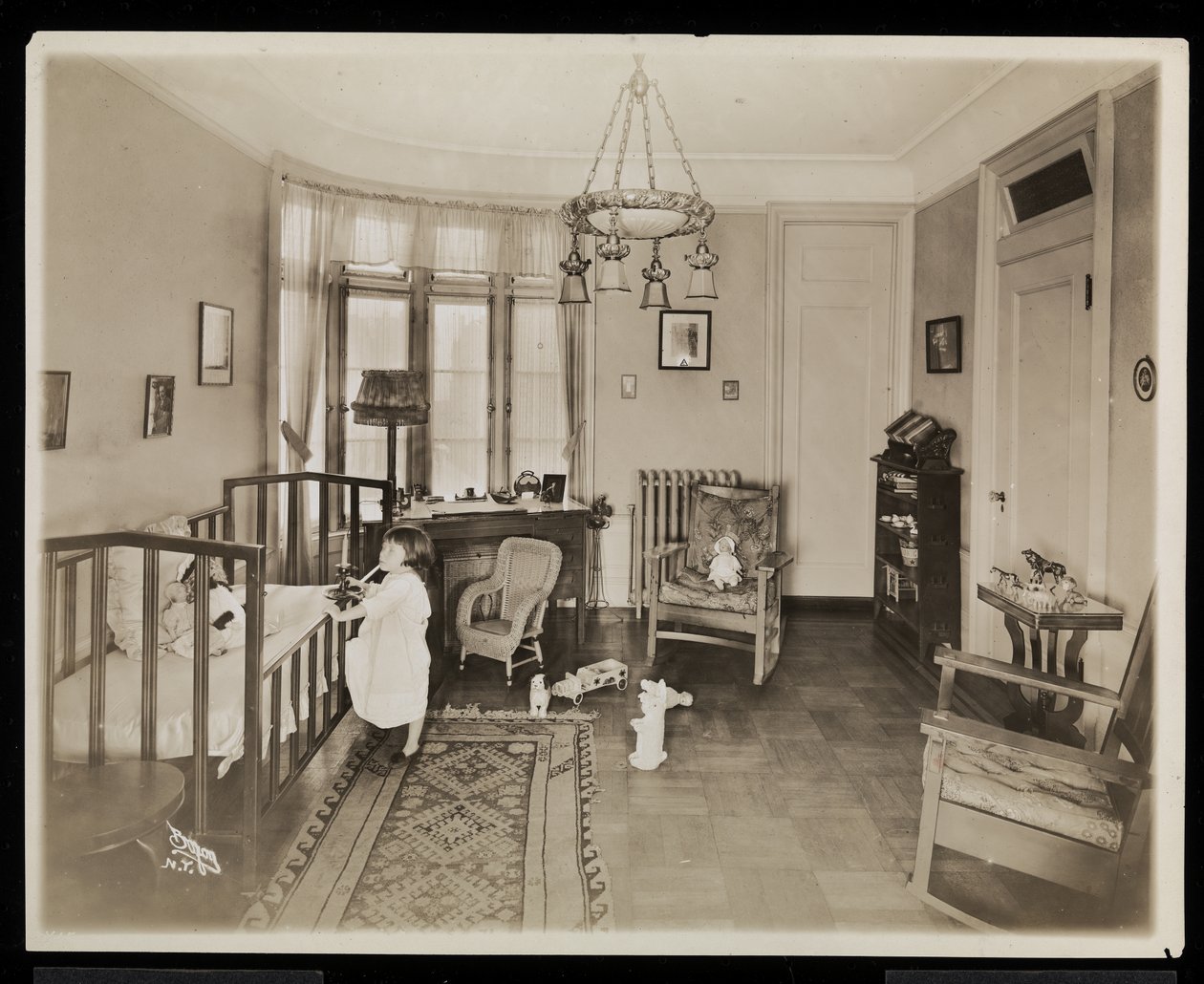 Dívka držící svíčku, lezoucí do postýlky, v ložnici rezidence AC Cronin, 1915-16 (stříbrný želatinový tisk) od Byron Company