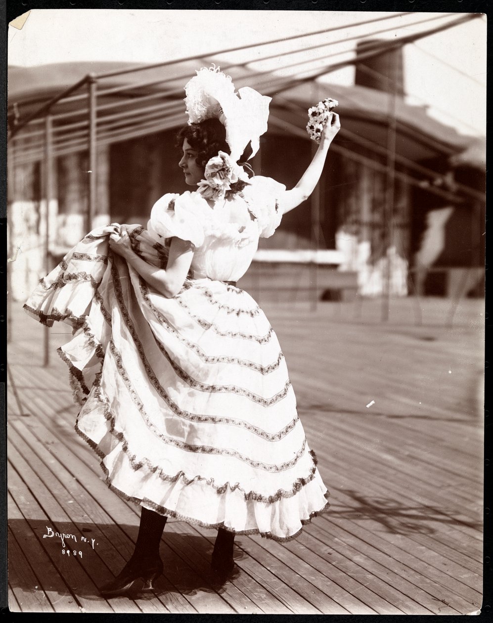 Herečka v kostýmu zkoušející na střeše toho, co je pravděpodobně New York Theatre, New York, 1900 (stříbrný želatinový tisk) od Byron Company