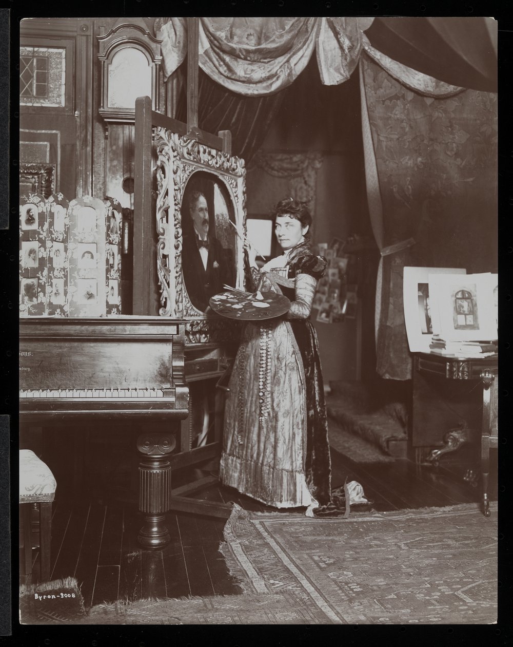 Umělkyně Mary Tillinghastová maluje portrét ve svém ateliéru, New York, asi 1897 (stříbrný želatinový tisk) od Byron Company