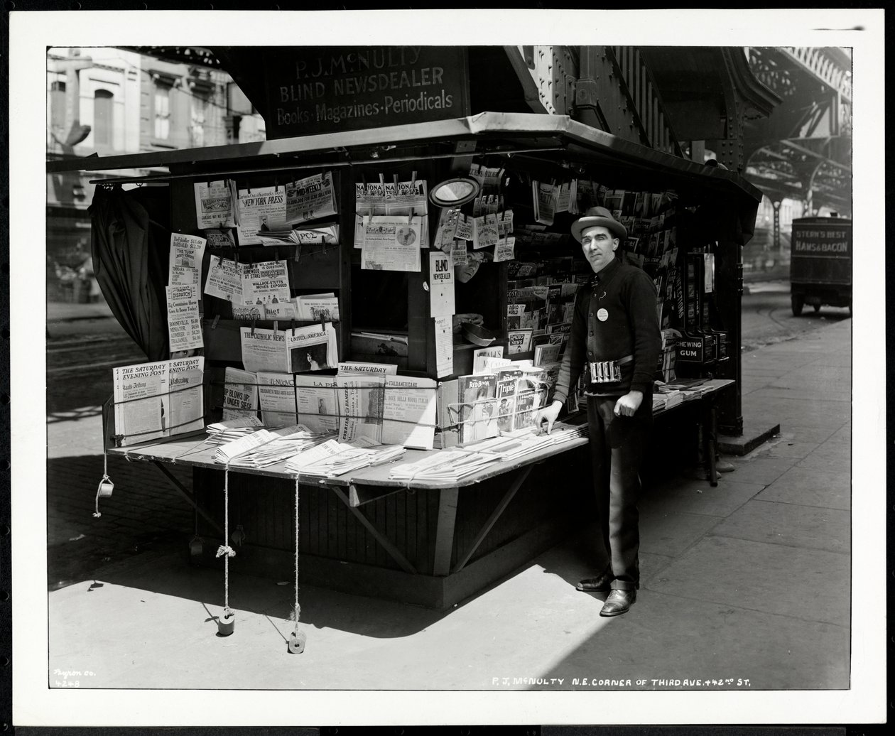 Slepý obchodník s novinami P. J. McNulty u svého stánku na severovýchodním rohu 3. avenue a 42. ulice, New York, 1926 (stříbrný želatinový tisk) od Byron Company