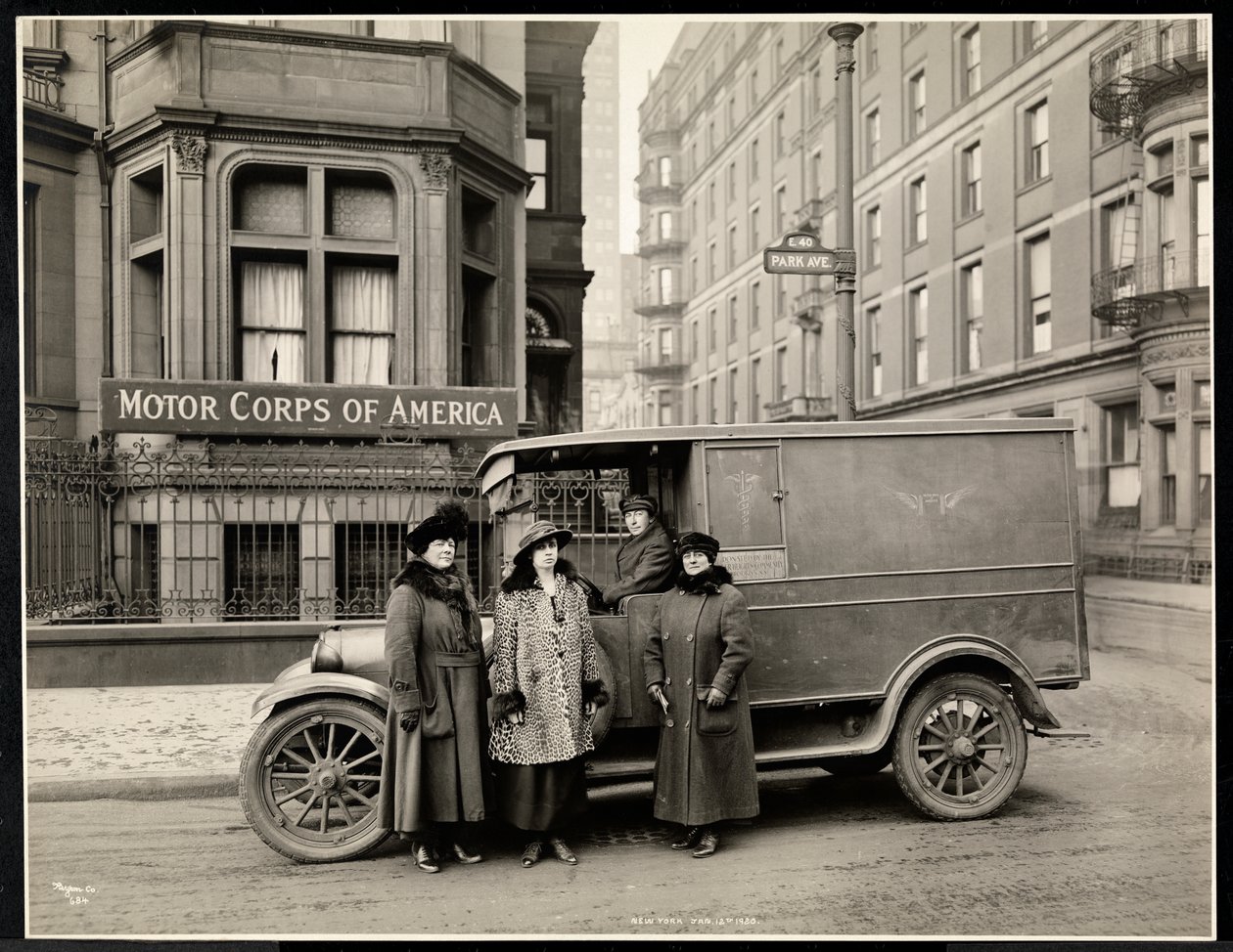 Čtyři ženy z Motor Corps of America stojící před sanitkou (jedna žena na sedadle řidiče) na Park Avenue na 40. ulici před budovou Motor Corps of America, New York, 1920 (s od Byron Company