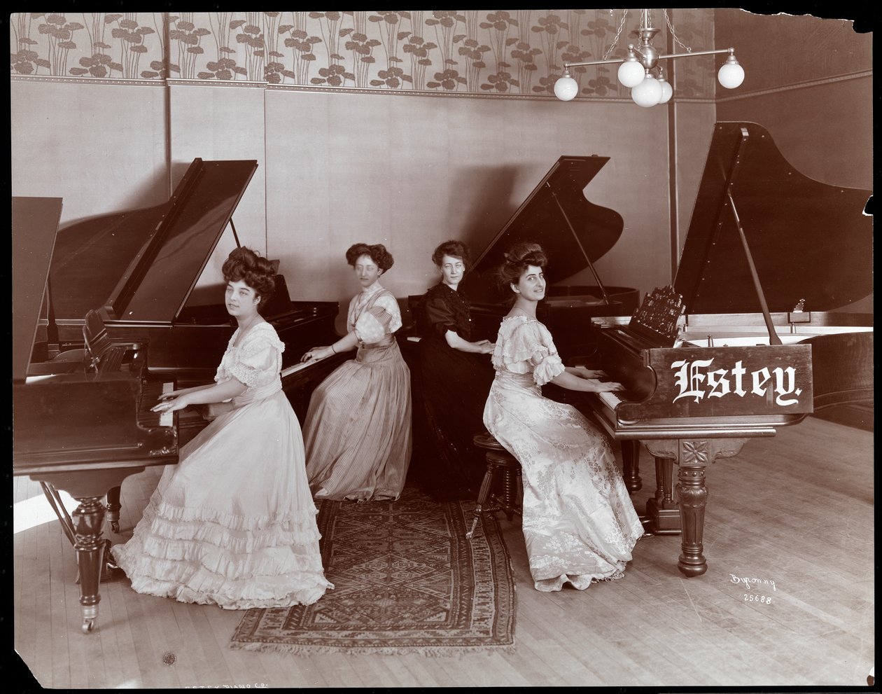 Čtyři ženy sedící u klavírů v Estey Piano Corporation, 1908 (stříbrný želatinový tisk) od Byron Company