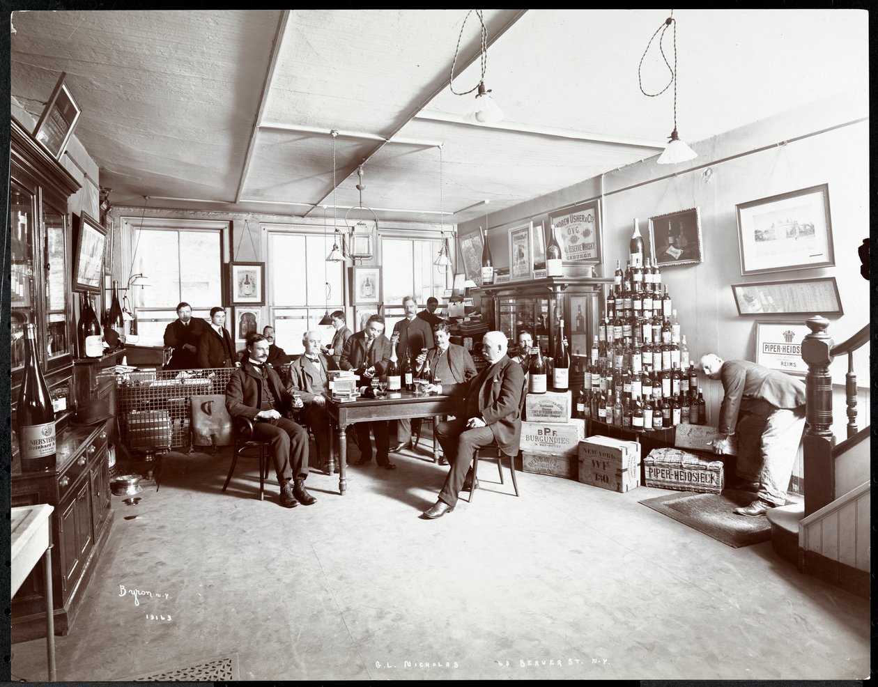 Skupina mužů popíjejících víno v obchodě s vínem a alkoholem G.L. Nicholas, Beaver Street 43, New York, 1895 (stříbrný želatinový tisk) od Byron Company