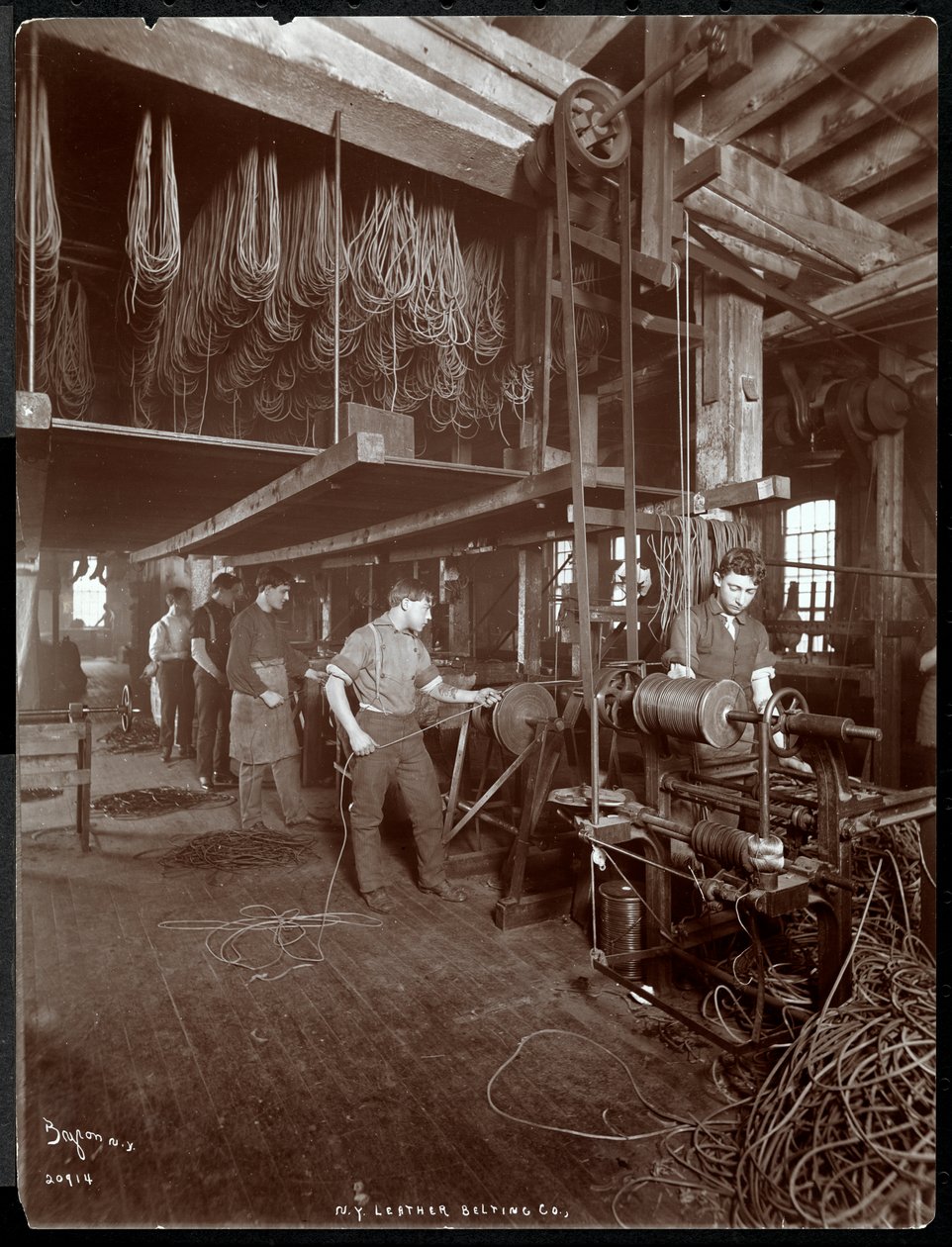 Vnitřní pohled na muže pracujícího s kůží v New York Leather Belting Co., New York, 1906 (stříbrný želatinový tisk) od Byron Company