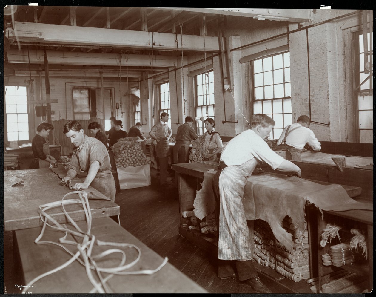 Vnitřní pohled na muže a ženy pracující s kůží v New York Leather Belting Co., New York, 1906 (potisk stříbrné želatiny) od Byron Company