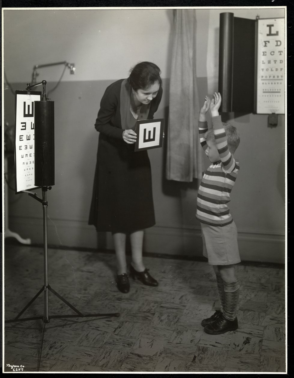 Zdravotní sestra a chlapec s očním testem v New York Association for the Blind, 111 East 59th Street, New York, 1930 (stříbrný želatinový tisk) od Byron Company