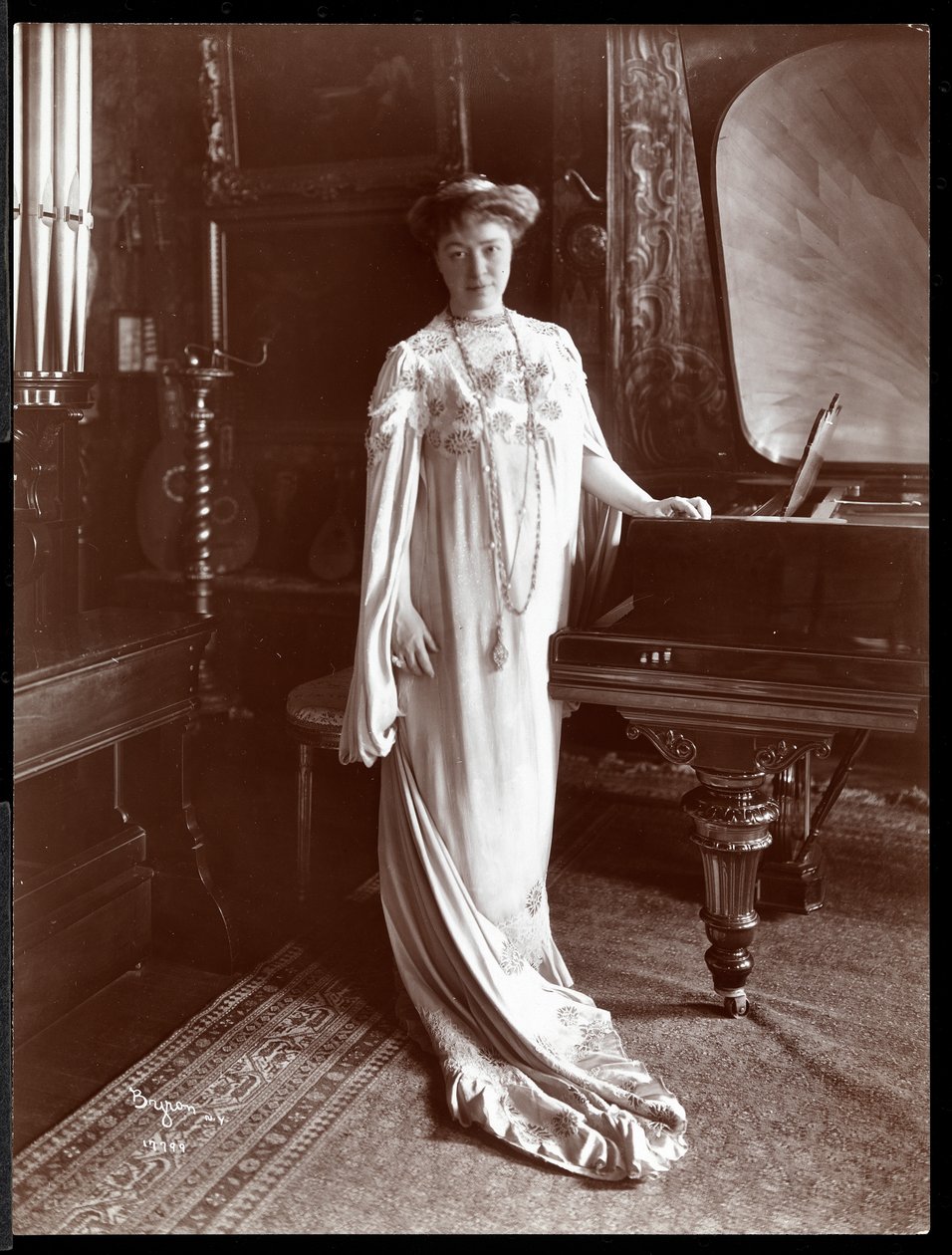 Portrét paní I. M. Clarkové stojící u klavíru, 1904 (stříbrný želatinový tisk) od Byron Company