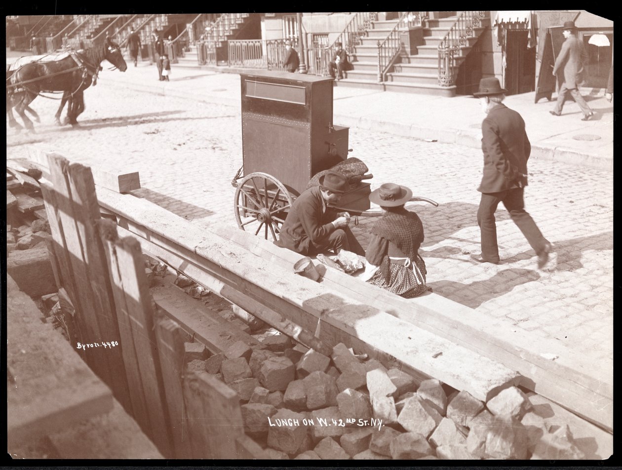 Pohled na pouličního varhaníka a ženu při obědě na Západní 42. ulici, New York, 1898 (stříbrný želatinový tisk) od Byron Company