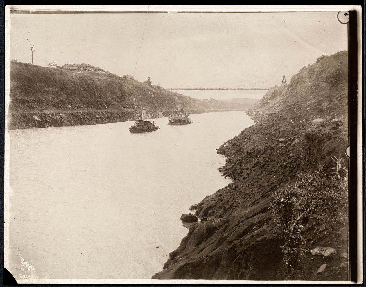 Pohled na dvě lodě v Panamském průplavu během jeho stavby s visutým mostem za ním, 1913 (potisk stříbrné želatiny) od Byron Company