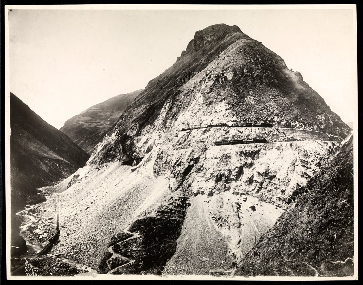 Pohled na dva železniční vlaky na kolejích podél hory, pravděpodobně na Panamském průplavu nebo v jeho blízkosti, 1912 nebo 1913 (potisk stříbrné želatiny) od Byron Company