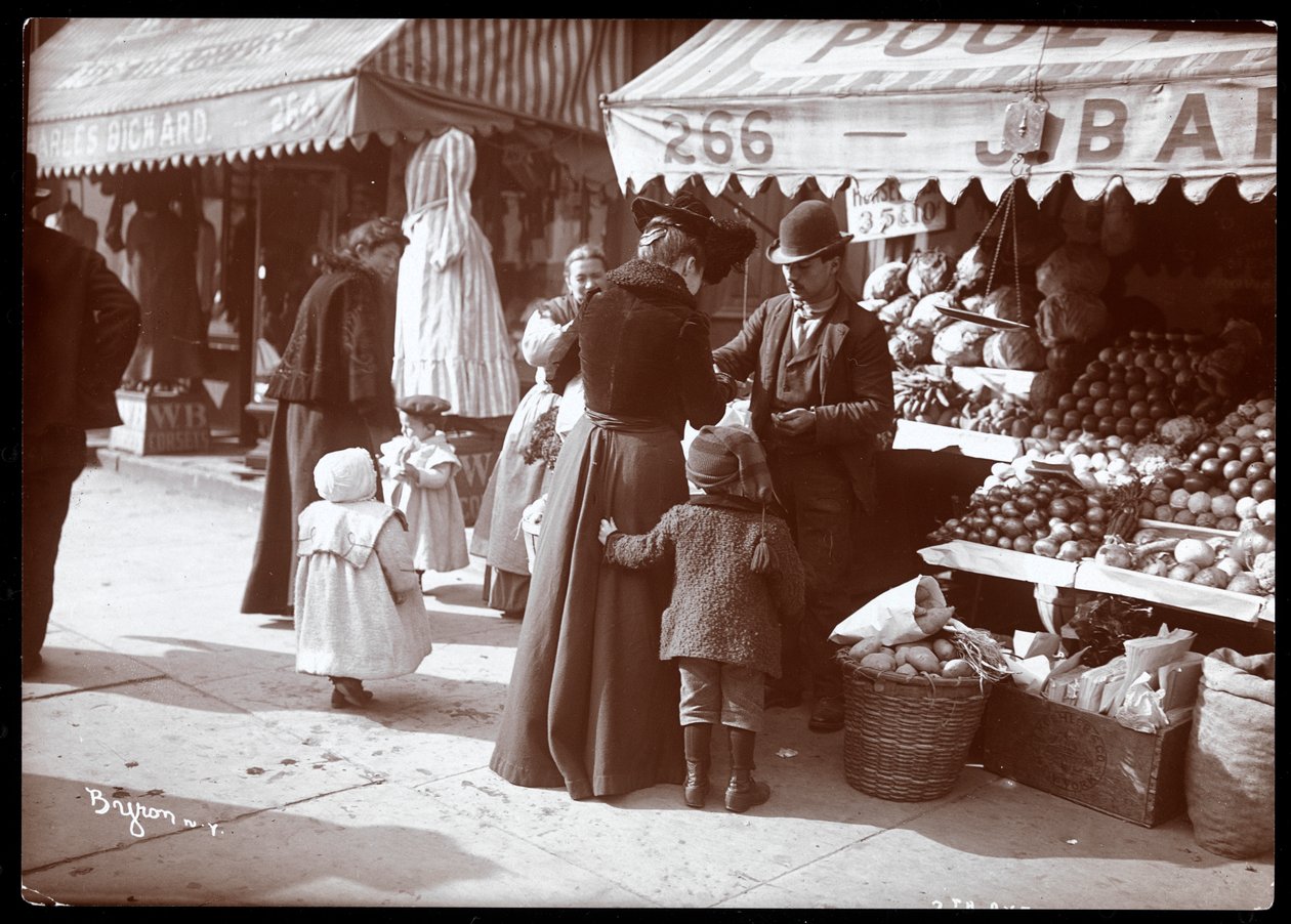 Pohled na ženy s dětmi nakupujícími ve stánku s ovocem a zeleninou na 266 7th Avenue, New York, cca 1900 (stříbrný želatinový potisk) od Byron Company