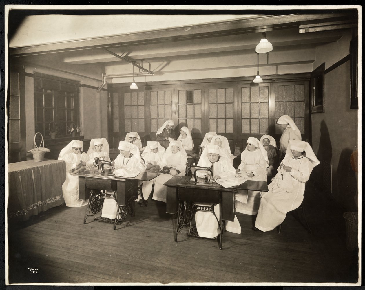 Ženy v bílých pláštích, na hodině šití, pravděpodobně během první světové války nebo v souvislosti s ní, New York, kolem roku 1920 (potisk stříbrné želatiny) od Byron Company