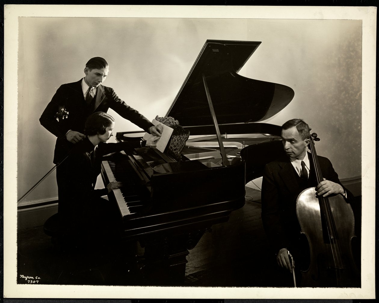 Slepá žena, slečna Hardingová, u klavíru vyučující dva slepé muže na housle a violoncello, 1936 (stříbrný želatinový tisk) od Byron Company