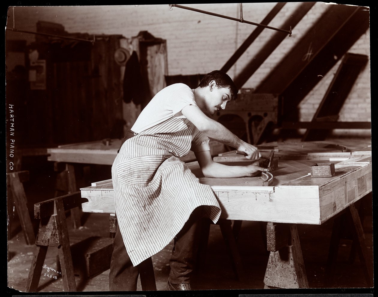 Muž pracující v továrně na klavír Hardman, Peck und Co., New York, 1907 (stříbrný želatinový tisk) od Byron Company