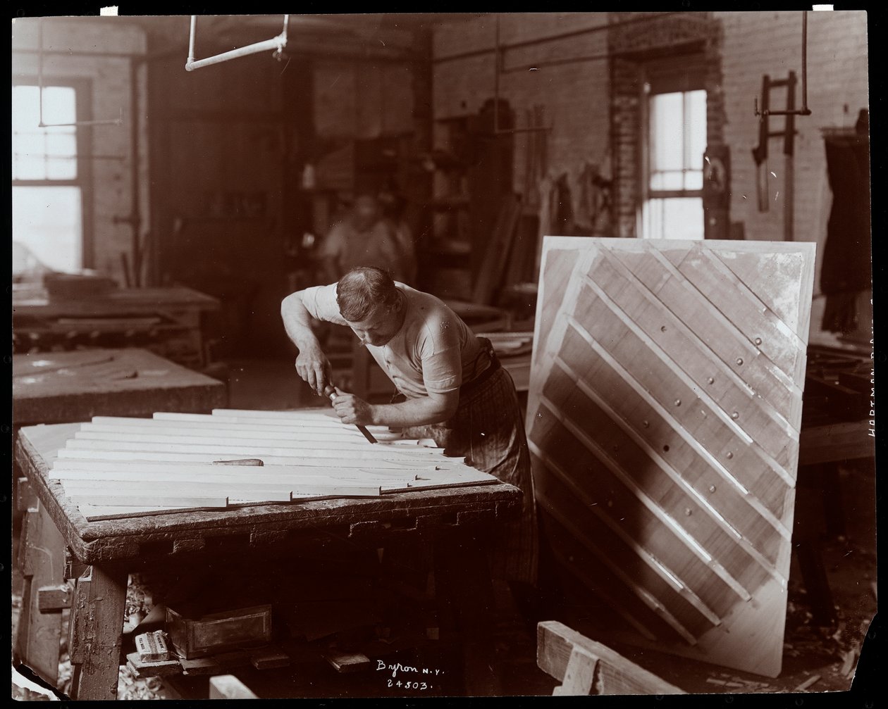 Muž pracující v továrně na klavír Hardman, Peck und Co., New York, 1907 (stříbrný želatinový tisk) od Byron Company