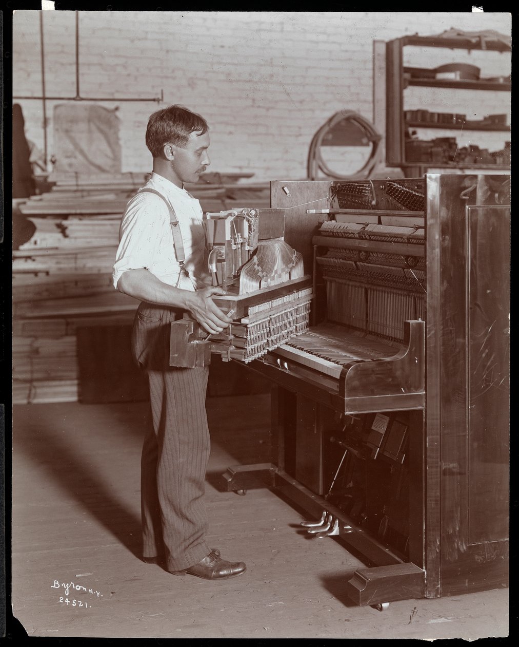 Muž pracující v továrně na klavír Hardman, Peck und Co., New York, 1907 (stříbrný želatinový tisk) od Byron Company