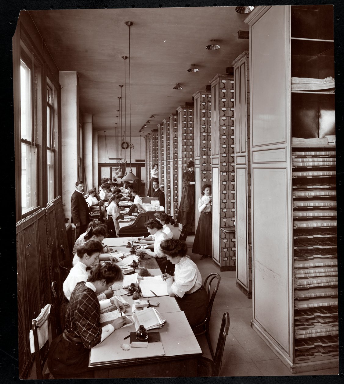 Ženy pracující pod mužským dohledem ve spisovně společnosti Metropolitan Life Insurance Co. na 23. ulici a Madison Avenue, New York, 1907 (stříbrný želatinový tisk) od Byron Company