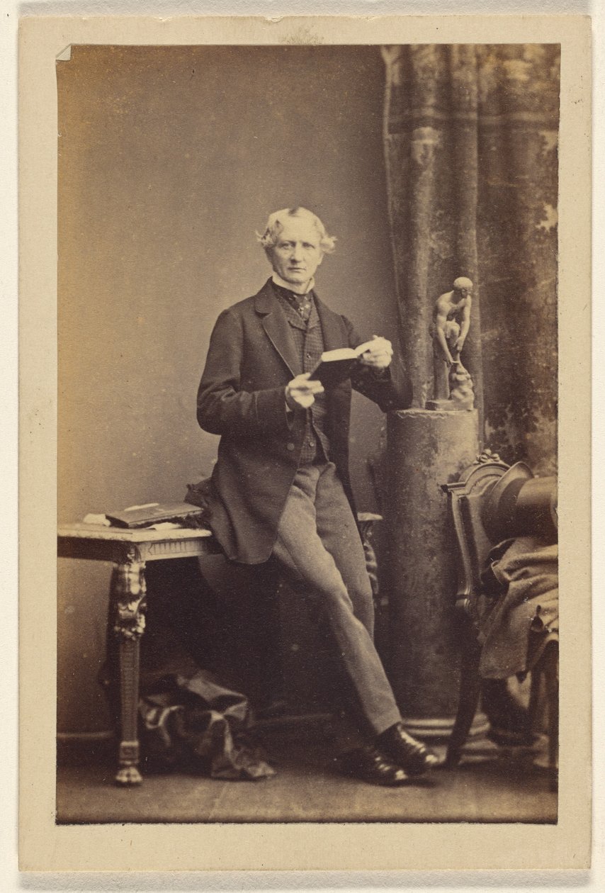 [Neznámý muž sedí na stole a drží otevřenou knihu] od Camille Silvy