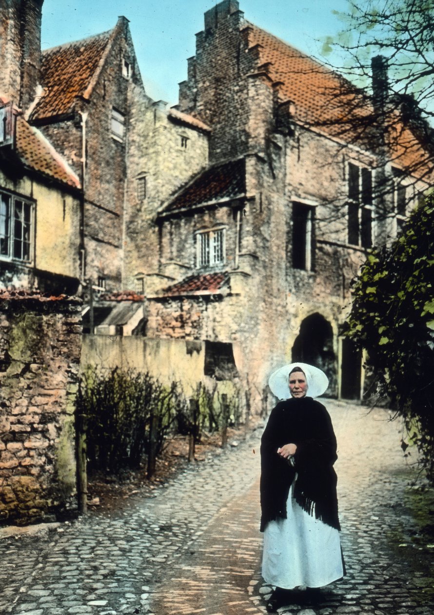 Nizozemsko, provincie Zeeland. Žena před portálem Kuipers ve městě Middelburg. Datum vyobrazení: kolem roku 1920. Archiv Carla Simona od Carl Simon