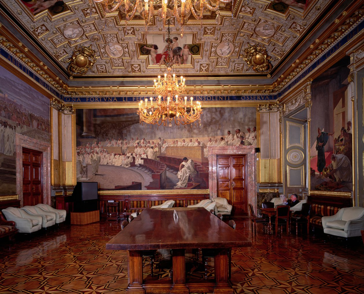 Místnost Sala Maccari Maccari bohatě zdobená zlaceným štukem a výjevy římské historie, detail panelu zobrazujícího římský senát, foto 1882-88 od Cesare Maccari