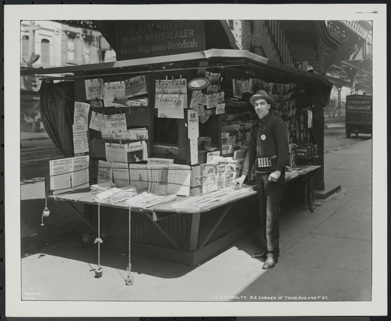 Prodejce slepých zpráv P.J. McNulty u svého stánku na severovýchodním rohu 3rd Avenue a 42nd Street od Company Byron
