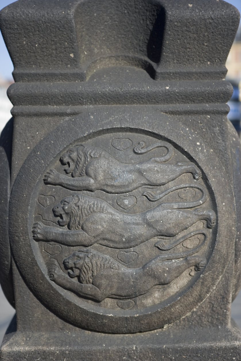 Symbol tří lvů vytesaný do kamenného sloupu na Radničním náměstí od Danish School