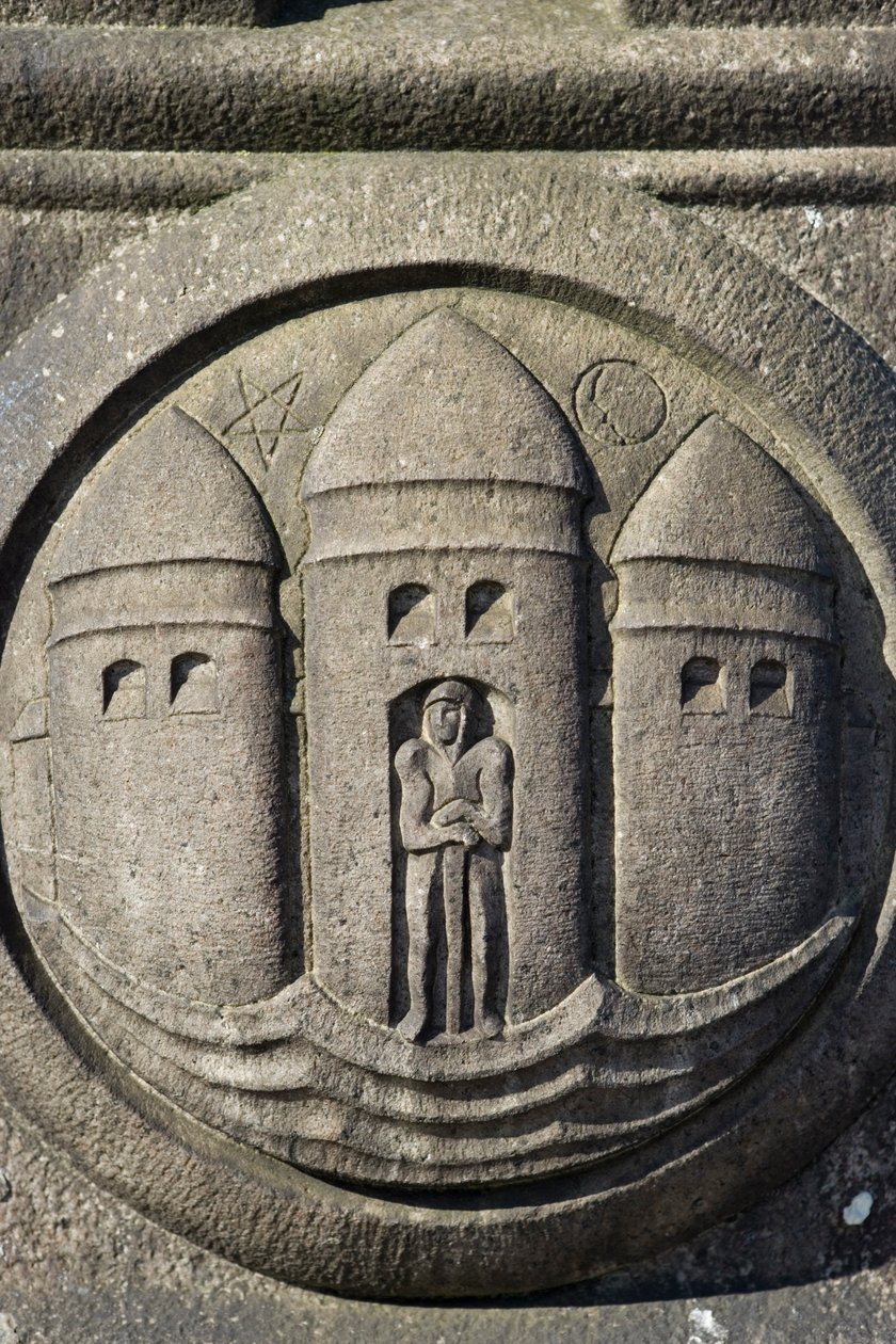 Symbol tří věží vytesaný do kamenného sloupu na Radničním náměstí od Danish School