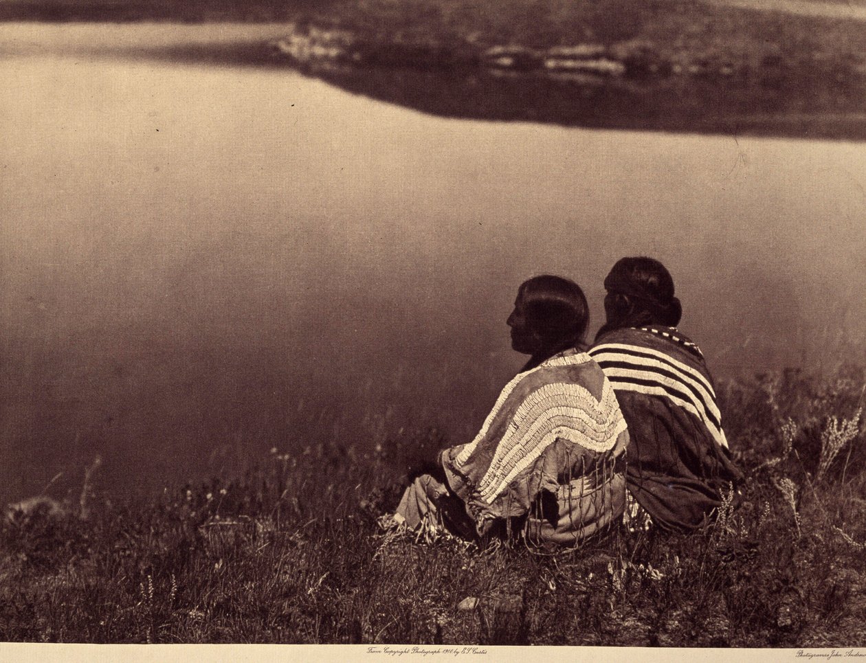 Hodina nečinnosti – Okamžik klidu: Indiáni Piegan sedí na okraji vodní plochy. Fotografie převzata ze svazku 6 encyklopedie vydané Edwardem S. Curtisem (1868-1952) o Indiánech Severní Ameriky, s předmluvou Theodora Roosevelta. B od Edward Sheriff Curtis