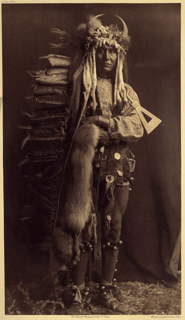 Železný Brest, Piegan. Kostým člena Bulls, bývalé společnosti, která na mnoho let zmizela Fotografie ze 6. dílu encyklopedie Edwarda S. Curtise (1868-1952) o Indiánech Severní Ameriky, s předmluvou Theodora Rooseva od Edward Sheriff Curtis