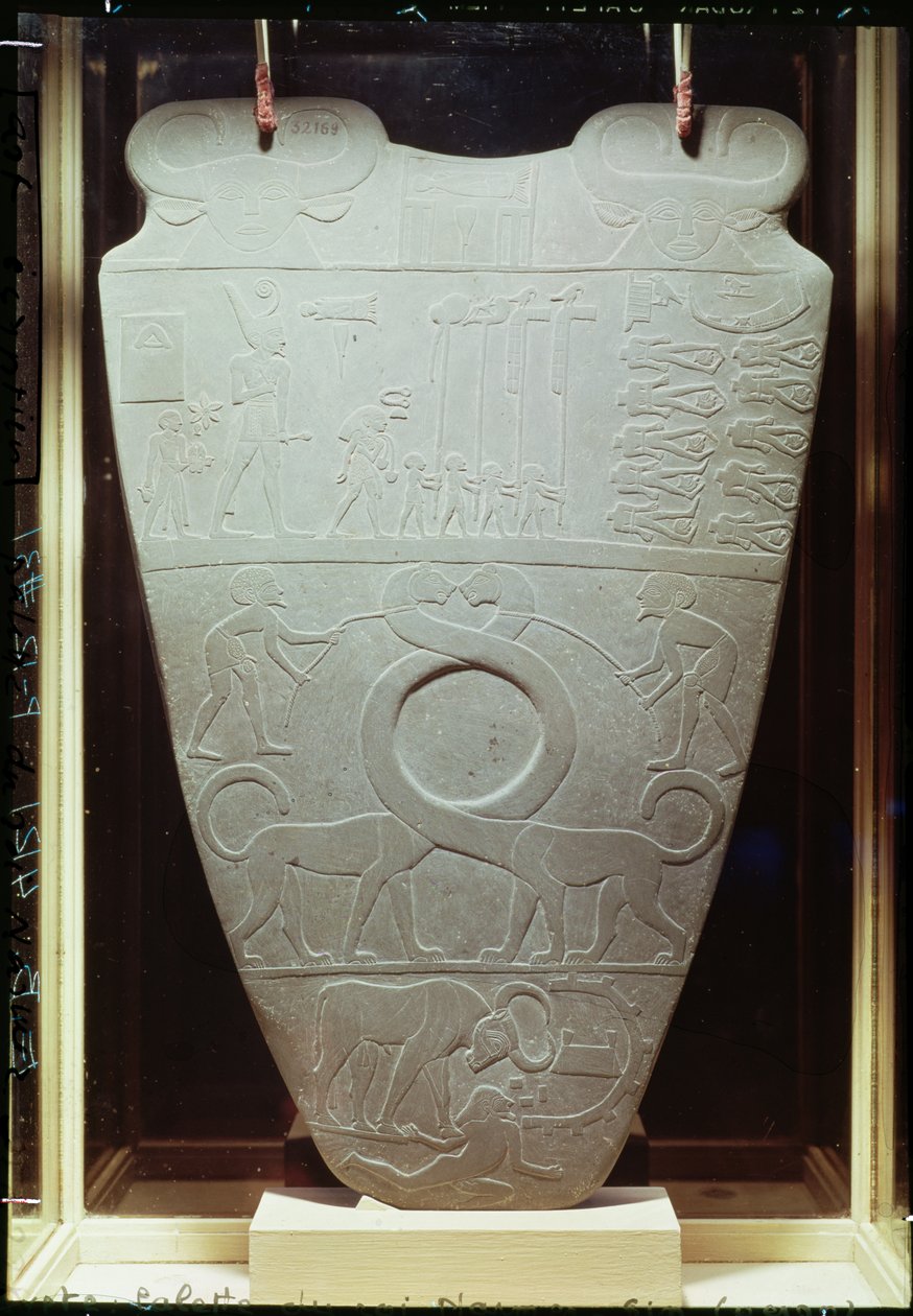 Narmerova paleta: obřadní paleta zobrazující krále Narmera s červenou korunou Dolního Egypta, který prohlíží spoutané a setnuté vězně, také pár obřích koček s dlouhým krkem, nalezených v Hieracu od Egyptian 1st Dynasty