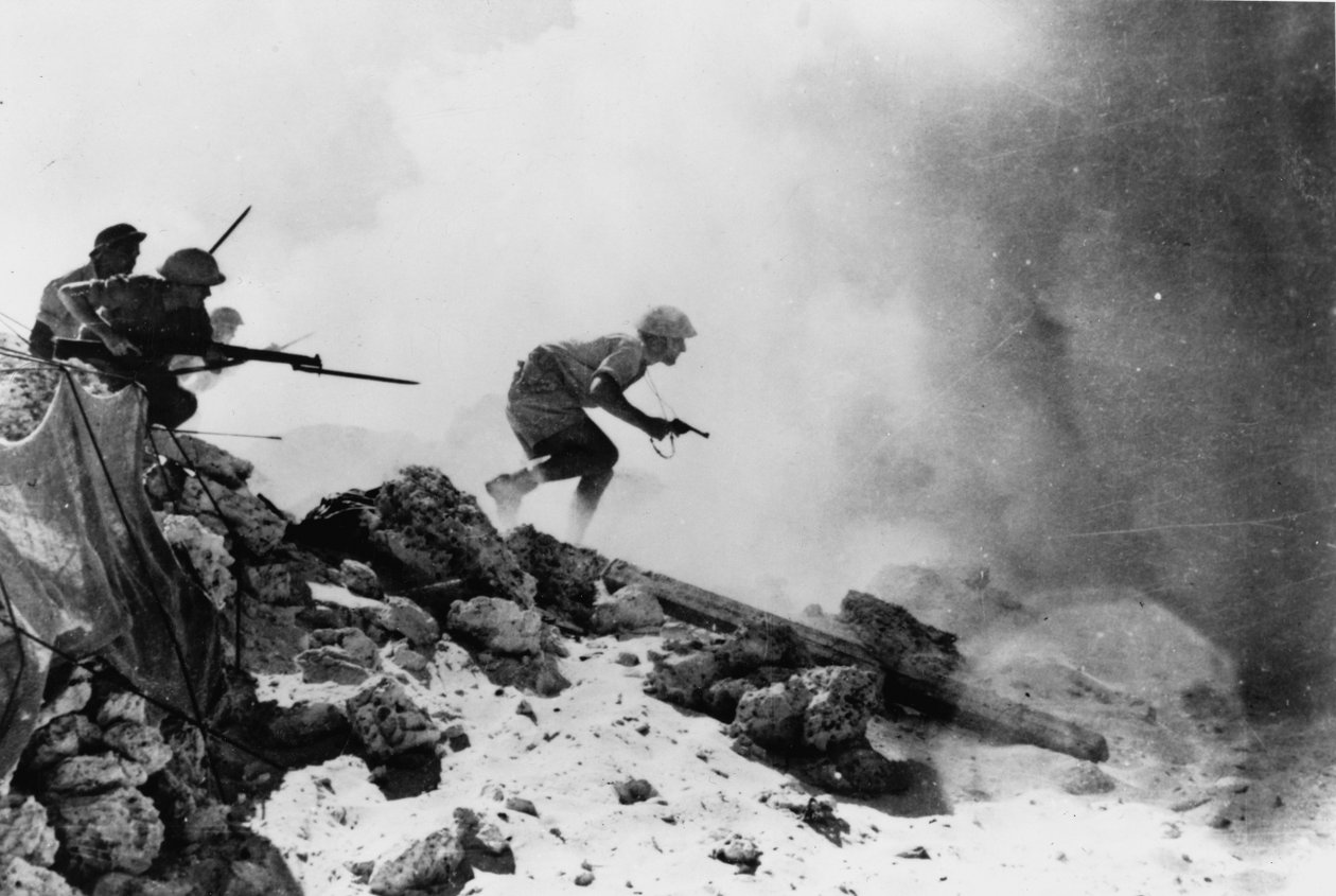 Britský důstojník vyzbrojený revolverem, který vede své muže vpřed s pevnými bajonety, jedna ze sedmi oficiálních fotografií týkajících se 2. bitvy u El Alameinu, 1942 od English Photographer