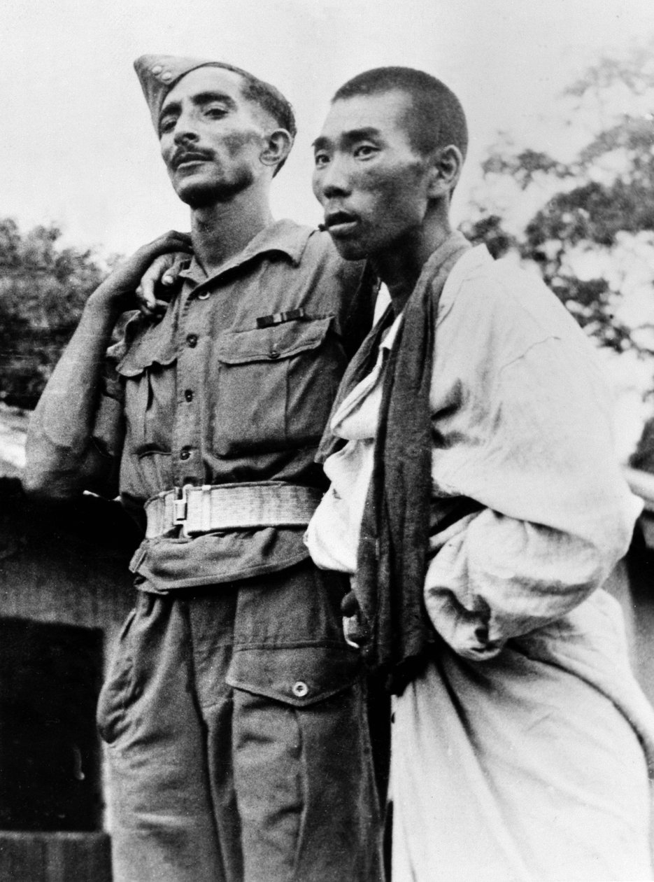 Zdravotník indické armády pomáhající zraněnému japonskému válečnému zajatci, 1945 od English Photographer